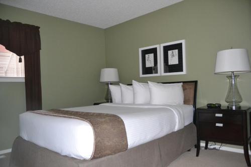 a bedroom with a large bed with white sheets and pillows at Village Creek Country Inn in Westerose