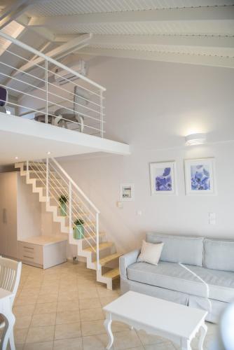 a living room with a couch and a staircase at Lefkadio in Lefkada Town