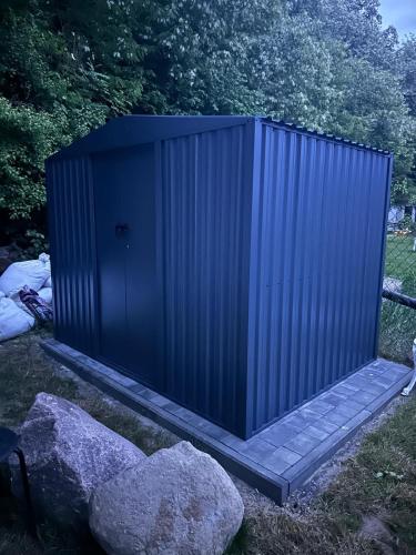 a blue container sitting next to some rocks at Domek Nad Odrą in Krajnik Dolny