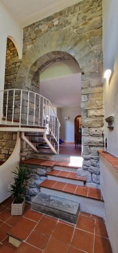a stone staircase in a building with a stone wall at Casa Brown - con piscina privata - in Barga
