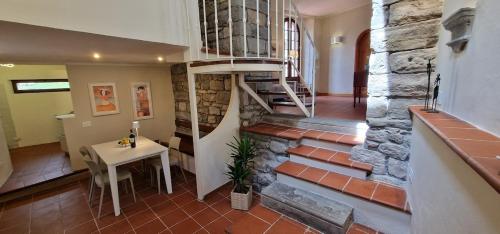 a staircase in a house with a table and a stair case at Casa Brown - con piscina privata - in Barga