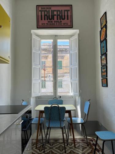a table and chairs in a room with a window at Charming 1-bed place in historic, vibrant Hamrun near Valletta in Hamrun