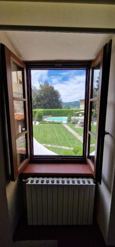 a window in a room with a view of a yard at Casa Brown - con piscina privata - in Barga
