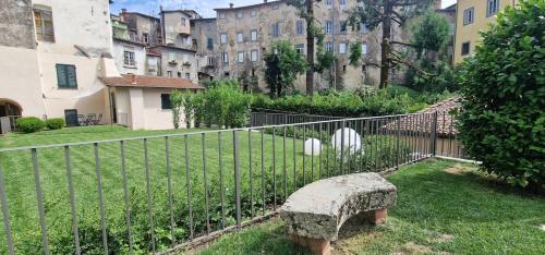a bench sitting next to a fence in a yard at Casa Brown - con piscina privata - in Barga