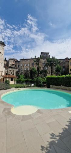 a large blue swimming pool with buildings in the background at Casa Brown - con piscina privata - in Barga