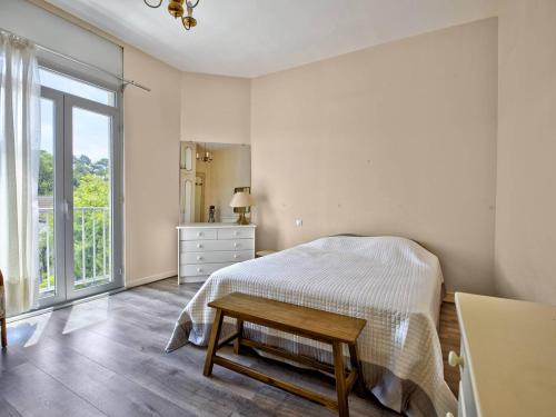a white bedroom with a bed and a table at Arcachon Pereire - T2 front de mer avec terrasse et parking, accès direct plage - FR-1-433-24 in Arcachon