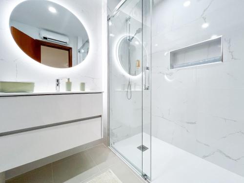 ein weißes Badezimmer mit Dusche und Spiegel in der Unterkunft Apartment Vila Marachique Sunlime Stay in Alvor