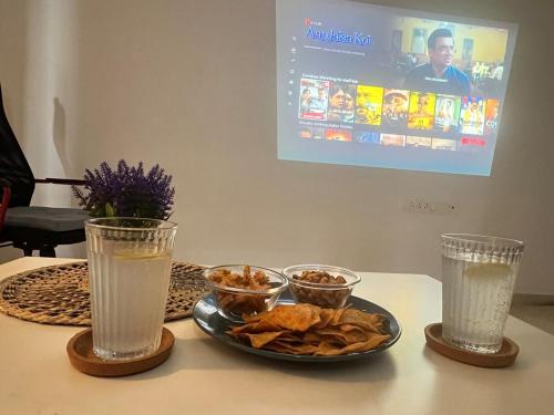 a table with a plate of food and two glasses at Havens home in Mangrul