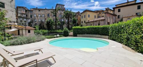a swimming pool in a yard with two chairs at Casa Brown - con piscina privata - in Barga