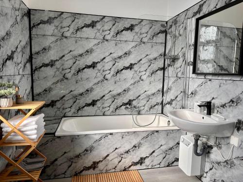 Un baño con bañera blanca y lavabo. en Arbeiter - Lounge 1, en Salzgitter