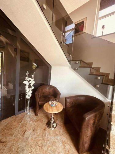 a living room with two chairs and a table at SWISS Apartment in Pokoj