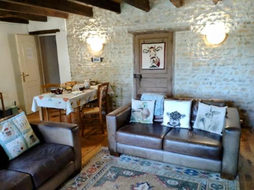 a living room with two leather couches and a table at B&B Franglaise in Romagne