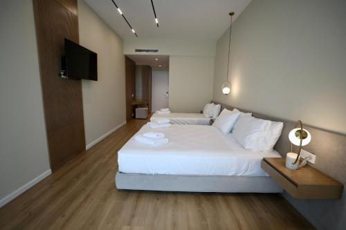 クサミルにあるHotel Panorama Ksamilの大きな白いベッドとテレビのある寝室