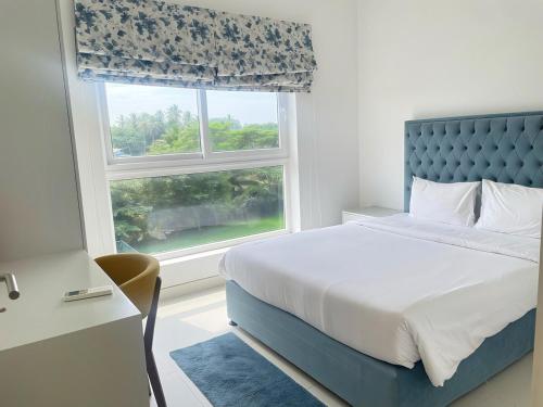 a bedroom with a bed and a window at Luxury Cozy Apartment - Fairway Galle in Galle