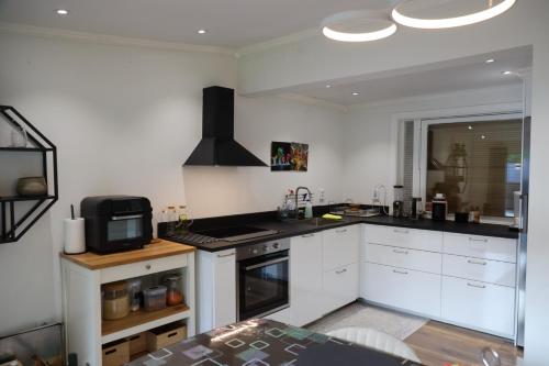 a kitchen with white cabinets and a stove top oven at Between the Trees in Gothenburg