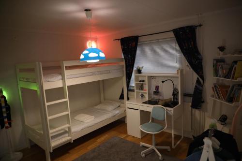 a bedroom with a bunk bed with a desk and a chair at Between the Trees in Gothenburg