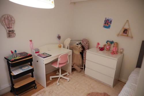 a bedroom with a desk and a dresser with dolls at Between the Trees in Gothenburg