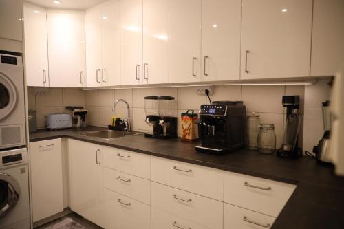 a kitchen with white cabinets and a counter top at Between the Trees in Gothenburg