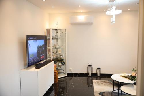 a living room with a flat screen tv on a white wall at Between the Trees in Gothenburg