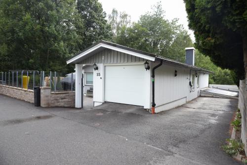a garage with a white door and a fence at Between the Trees in Gothenburg