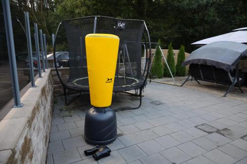 a yellow baseball bat on a stand on a sidewalk at Between the Trees in Gothenburg