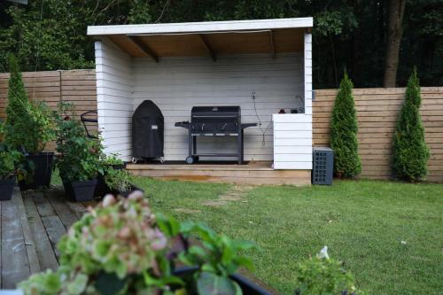 a barbecue grill in a shed in a yard at Between the Trees in Gothenburg