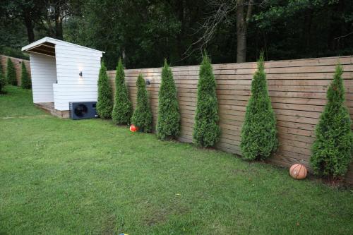 a fence with a dog house and a row of trees at Between the Trees in Gothenburg
