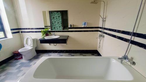 a bathroom with a tub and a toilet and a sink at Ninh Binh Kong's Homestay in Nguyên Ngoại