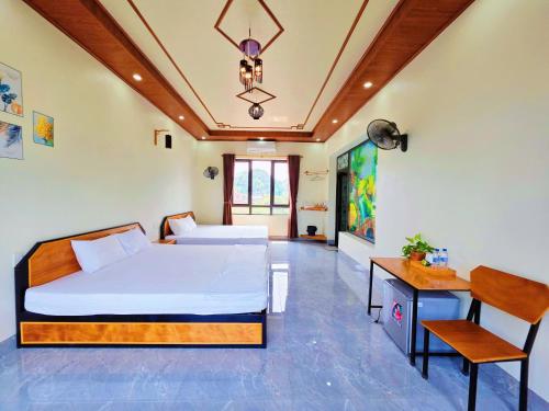 a bedroom with two beds and a table and a chair at Ninh Binh Kong's Homestay in Nguyên Ngoại