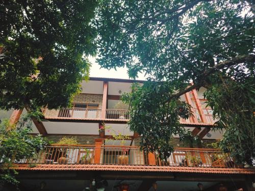 a building with a balcony and trees at Ninh Binh Kong's Homestay in Nguyên Ngoại