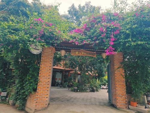 a brick arch with pink flowers on it at Ninh Binh Kong's Homestay in Nguyên Ngoại