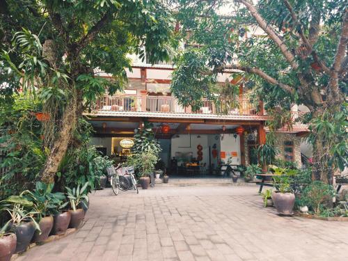 a courtyard with a building with trees and plants at Ninh Binh Kong's Homestay in Nguyên Ngoại
