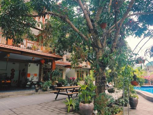 a picnic table under a tree next to a pool at Ninh Binh Kong's Homestay in Nguyên Ngoại