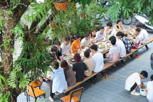 a group of people sitting at long tables eating food at Ninh Binh Kong's Homestay in Nguyên Ngoại