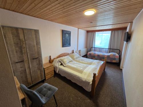 a bedroom with a bed and a chair in it at Landgasthof Frankentor in Wasserlosen