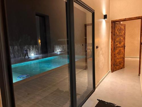 a swimming pool is seen through a glass door at Dar essafae in Essaouira