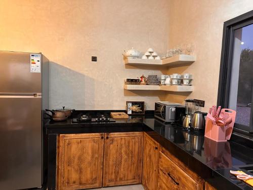 a kitchen with black counter tops and a stainless steel refrigerator at Dar essafae in Essaouira