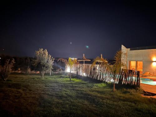 a yard with trees and a building at night at Dar essafae in Essaouira