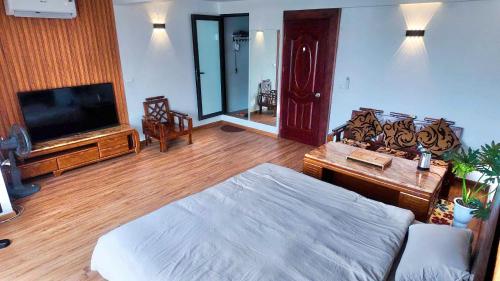 Un dormitorio con una cama, un televisor y una mesa. en Midtown home, en Hanói