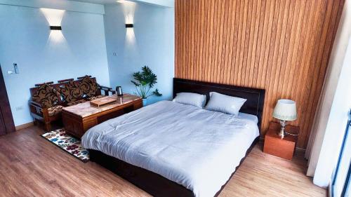Un dormitorio con una cama grande y una mesita de noche. en Midtown home, en Hanói