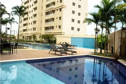 a swimming pool in front of a large building at COP 30 Apartamento Luxo - 3 Quartos, Piscina, Academia, Area de Lazer in Belém