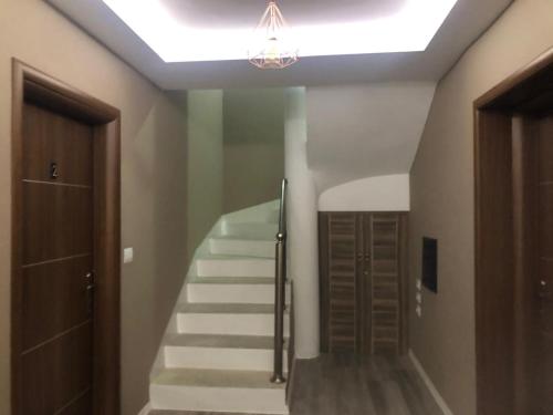 a staircase in a room with a light and a stair case at Vila Culli in Përmet