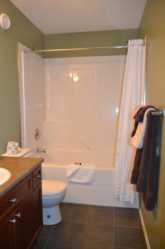 a bathroom with a tub and a toilet and a shower at Village Creek Country Inn in Westerose