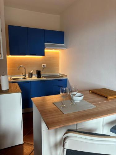 a kitchen with blue cabinets and two wine glasses on a table at Casa dell'Acqua - Isola d'Elba in Rio nellʼElba