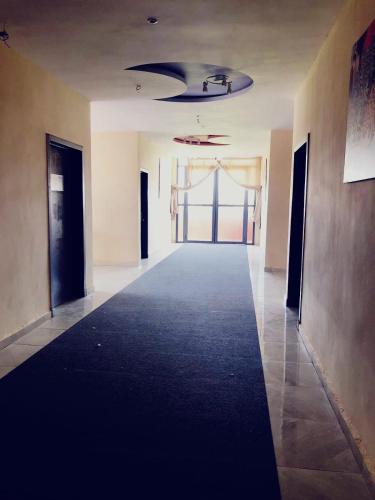 an empty hallway in an office building with a black carpet at Hotel Family Park in Marrakech