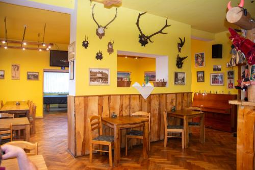 a restaurant with wooden tables and antlers on the wall at Penzion Čertovy Kameny in Jeseník