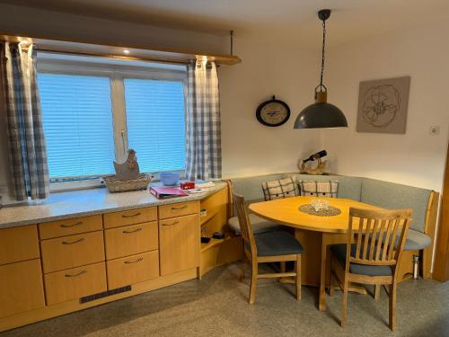 cocina con mesa, mesa pequeña y sillas en Haus Leiner, 