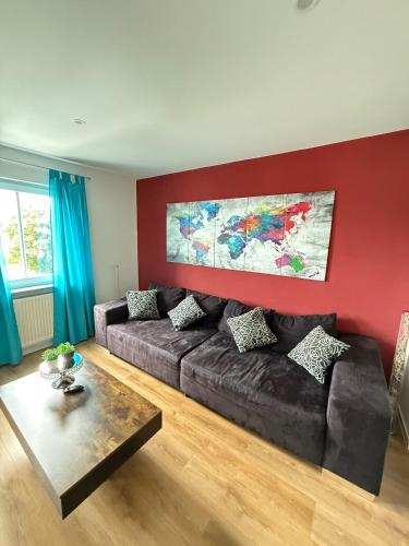 a living room with a couch and a red wall at Charmantes Apartment in Dettingen an der Erms in Dettingen an der Erms