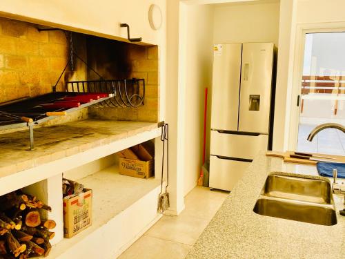 a kitchen with a sink and a refrigerator at LUX TOWER Punta del Este Port in Punta del Este