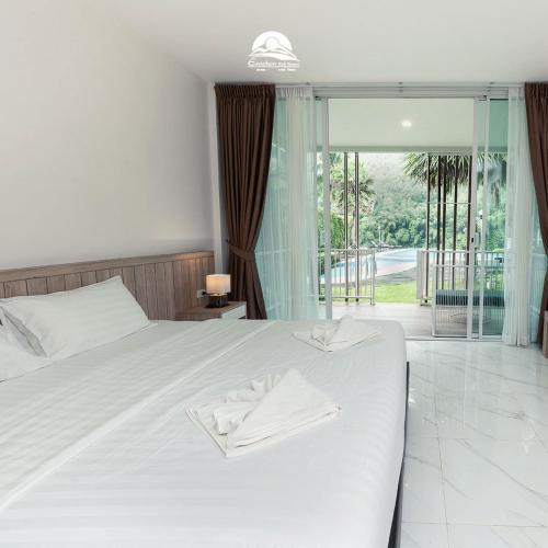 a bedroom with a bed with two towels on it at Erachon Raft Resort in Ban Tha Thong Mon